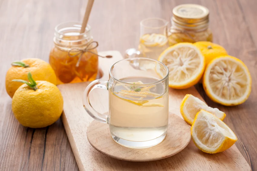 감기 예방을 위해 따뜻하게 우려낸 유자차 한 잔과 곁들여진 신선한 유자 조각 가니쉬