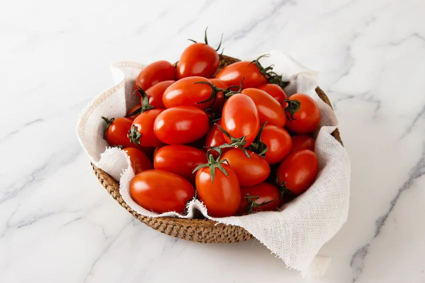 스테비아 토마토, 대리석 바닥 위 갈색 바구니에 흰 천을 깔고 그 위에 선홍빛의 싱싱한 스테비아 대추방울토마토가 가득 담겨 있는 모습