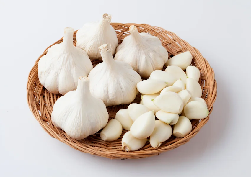 마늘, 원형 나무 바구니 안에 신선한 통마늘들과 깐마늘 알갱이들이 깔끔하게 담겨 있는 연출 컷 사진